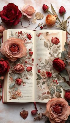 an open book surrounded by flowers and leaves on top of a white table with hearts