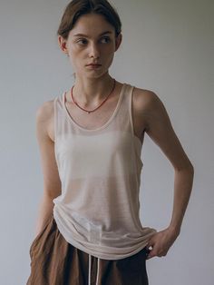 This is vanone atelier’s lightweight sheer fabric with just the right amount of translucency to avoid feeling overwhelming. Its soft and stretchy texture drapes nicely along the body, providing a comfortable and effortless fit. You can pair it as a set with a T-shirt made from the same fabric. - Perfect for everyday wear- Can be styled with various styles of bottoms for different looks- A versatile item that pairs well with any outfit Sheer Stretch Tank Top, Sheer Tank Top For Layering, Sheer Sleeveless Beige Top, Sheer Tank Top For Summer Layering, Sleeveless Sheer Beige Tops, Beige Sheer Sleeveless Top, Sheer Tank Top For Layering In Spring, Spring Sheer Tank Top For Layering, Effortless Tank Top For Summer Layering