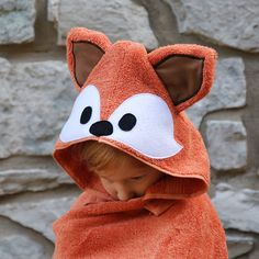 a little boy wearing a towel with a fox face on it