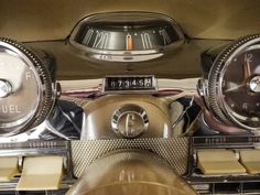 the dashboard of an old car with two clocks on it's sides and four speedometers