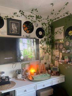 a desk with a computer monitor, keyboard and various pictures on the wall