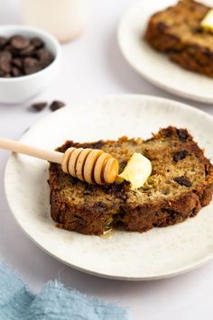 there is a piece of bread on the plate with butter and honey on it next to some chocolate chips