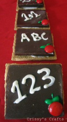 three decorated cookies with numbers and apples on them