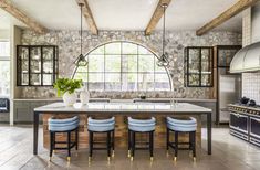 a kitchen with stone walls and an arched window