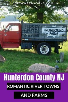 a red truck parked in the grass next to a tree and rocks with words hunterdon county, n j romantic river towns and farms