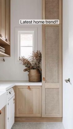 a kitchen with white counter tops and wooden cabinets in front of a window next to a washer and dryer