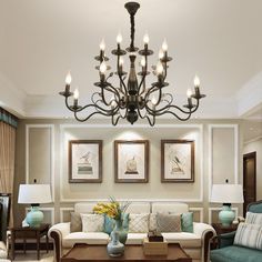 a living room filled with furniture and a chandelier hanging over the top of it