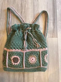 a green crocheted purse sitting on top of a wooden floor