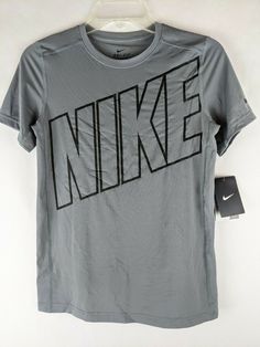 New with Tags Nike Boys Gray Short Sleeve Dri-Fit Athletic Activewear Shirt  Item #827994 Youth Boys Size: Large Color:  Gray with black NIKE logo on front Swish on sleeve Round collar Short Sleeves Dri-Fit Tagless Retail MSRP:  $25 Material:  92% Polyester, 8% Spandex Material care:  Machine wash, cold and Tumble dry, low Approximate measurement of garment, laying flat: Armpit to Armpit:  16-1/2" Length:  23" Nike Cotton Top With Logo, Nike Cotton Tops With Logo, Nike Fitted Sports Shirt, Nike Fitted Shirt For Sports, Nike Gray T-shirt With Logo Print, Fitted Nike Sports Shirt, Fitted Nike Shirt For Sports, Nike Gray Tops With Letter Print, Sports Graphic Print Gray Shirt