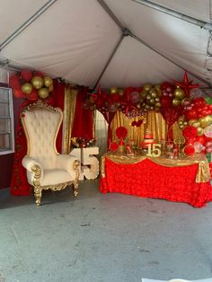 a red and gold party setup with chairs, tables and balloons on the wall behind it