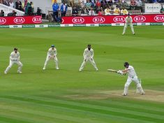 the men are playing a game of cricket on the field