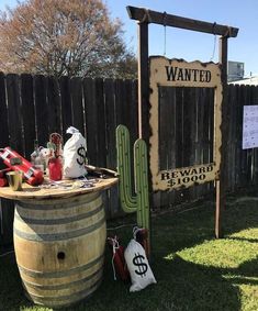 a wooden barrel sitting in the grass next to a sign that says, wanted re - wood $ 500