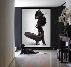 a dog laying on the floor in front of a framed photo with a woman's body