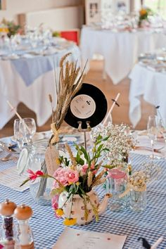 the table is set up for a wedding reception with flowers and place cards on it