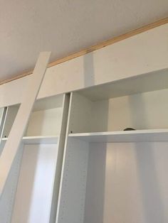 an empty closet with white shelves and drawers