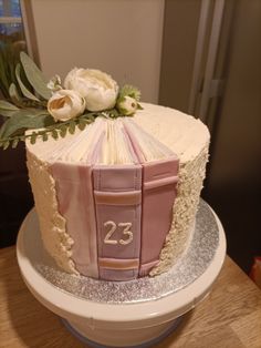 a cake decorated with an open book and flowers