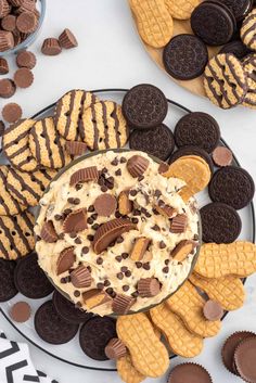 an assortment of cookies and crackers on a platter with the dip in it