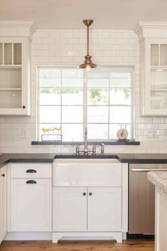 a kitchen with white cabinets and black counter tops