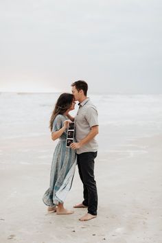 an engaged couple kissing on the beach