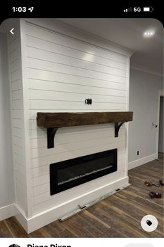 the fireplace is being installed in the living room with wood flooring and white walls