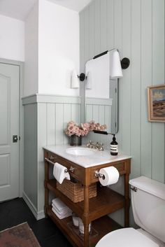 a white toilet sitting next to a sink in a bathroom under a vanity with two towels on it