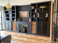 a living room filled with furniture and a fire place in front of a fireplace covered in logs