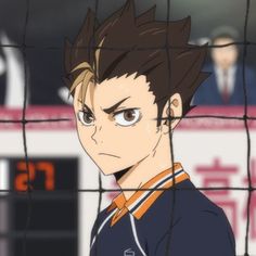 an anime character with short hair and brown eyes standing in front of a goalie net