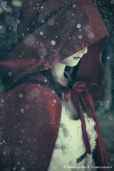 a woman wearing a red cape with snow falling on her head and the words, think i'll miss you forever like the stars miss the sun in the morning