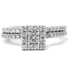 a white gold ring with two rows of diamonds on the band and a princess cut diamond in the center