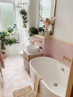 a bath room with a tub a sink and a rug on the floor in front of a window