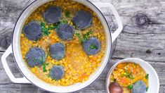 two bowls filled with food on top of a wooden table