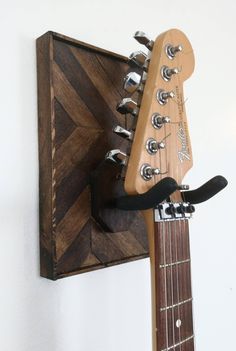 an electric guitar mounted on a wall with a wooden head and neck piece attached to it