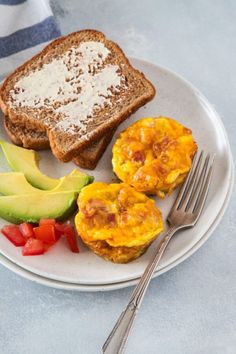 an omelet with toast, avocado and tomatoes on a plate