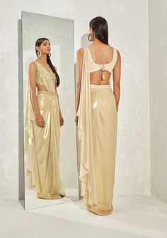 Editor's Note This set features a stunning gold shimmer foil crepe corset with a pleated draped sari and belt. The sari is elegantly pleated and draped with a metallic edge, creating a unique and modern look. Color: Gold Fabric: Shimmer foil crepe Component: Sari and corset Occasion: Cocktail and Wedding Guest Disclaimer: Product color may slightly vary due to photographic lighting sources or your monitor setting. Care: Dry clean only About the Designer Namrata Joshipura's design vision is globa Namrata Joshipura, Blouses Pattern, Draped Saree, Saree For Women, Drape Saree, Black Saree, Color Pairing, Metallic Fabric, Gold Fabric