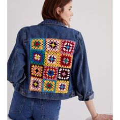 a woman is wearing a jean jacket with colorful squares on the front and back side