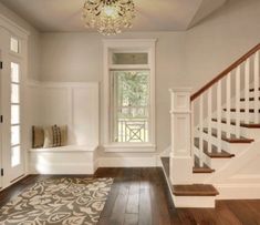 an empty entryway with stairs leading up to the second floor and a chandelier hanging from the ceiling