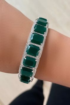 Silver toned bangle with emeralds and swarovski diamonds embellishments. - Aza Fashions Formal Silver Diamond Bracelet With Emeralds, Formal Emerald Gemstone Bracelets, Luxury Diamond Bracelets With Stones, Luxury Green Diamond Bracelet Hand Set, Formal Silver Bracelet With Emerald, Luxury Green Hand Set Diamond Bracelet, Formal Silver Emerald Bracelet, Formal Green Bracelets With 17 Jewels, Fine Jewelry Emerald Diamond Bracelet For Wedding