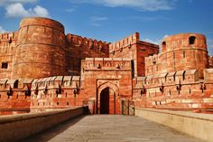 a large brick building with two towers on each side and a walkway leading to the entrance