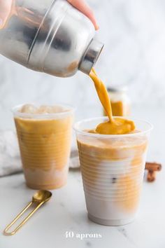 a person pouring orange juice into two cups