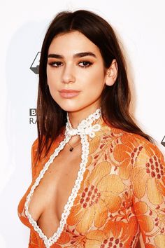 a close up of a person wearing an orange dress