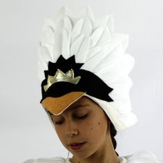 a woman wearing a white and black headband with gold crown on it's head