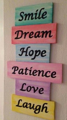 three wooden signs that say smile, dream, hope, love and laugh on the wall