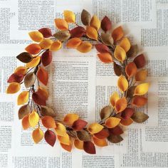 a wreath made out of leaves sitting on top of an open book