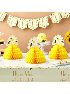 a table topped with yellow honeycombs and cupcakes