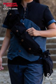 a woman wearing a black and blue shirt carrying an arm sling in her right hand