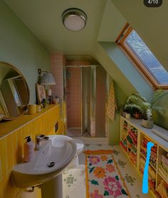 a bathroom with yellow and pink tiles on the floor, shower stall and sink area