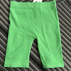 a pair of green shorts sitting on top of a bed