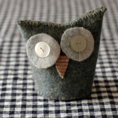 an owl made out of felt sitting on top of a checkered table cloth