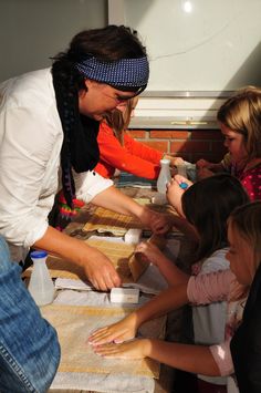 a group of people standing around a table with cups and napkins on top of it