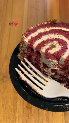 a piece of cake on a black plate with a fork next to it and the rest of the cake has been cut